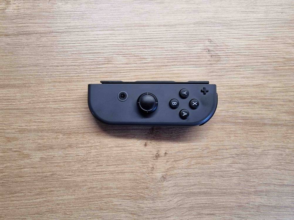 Spielekonsolen im Test: Ein schwarzer Controller liegt auf einer Holzfläche.