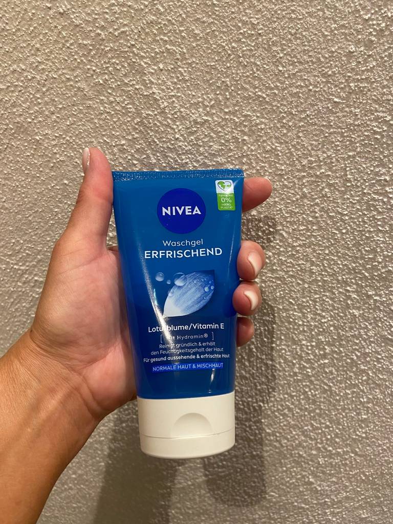 Eine Hand hält die NIVEA-Tube inklusive der milden Gesichtsreinigung im Test vor einer weißen Oberfläche.