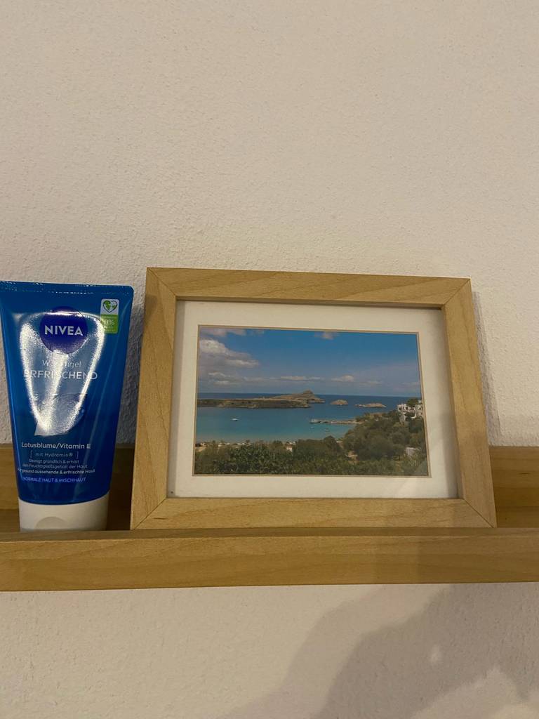 Getestet: Die milde Gesichtsreinigung von NIVEA in der Tube steht neben einer gerahmten Postkarte mit Meeresmotiv.