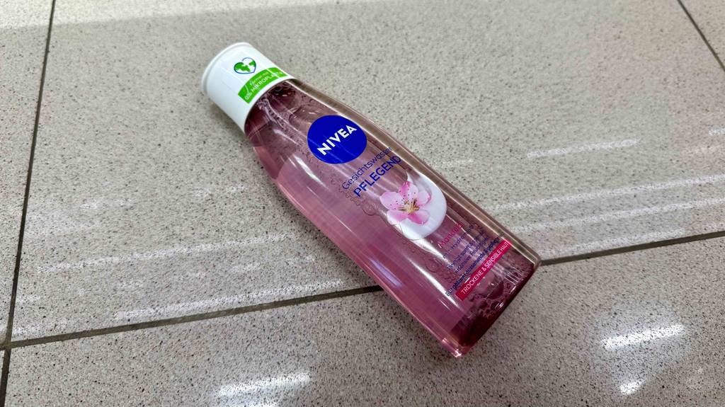 Eine Flasche getestetes Nivea-Gesichtswasser liegt quer auf Fliesen.