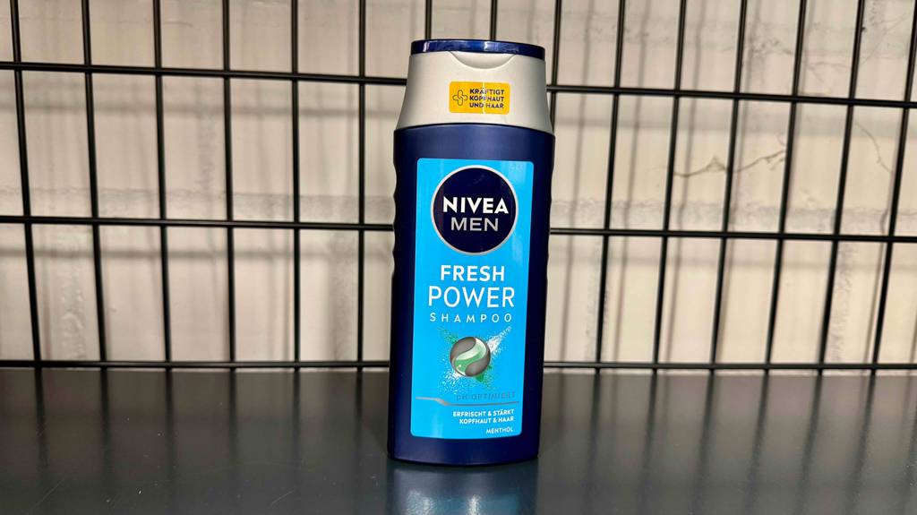 Eine Flasche Männer-Shampoo steht zum testen in einem schwarzen Gitterregal.