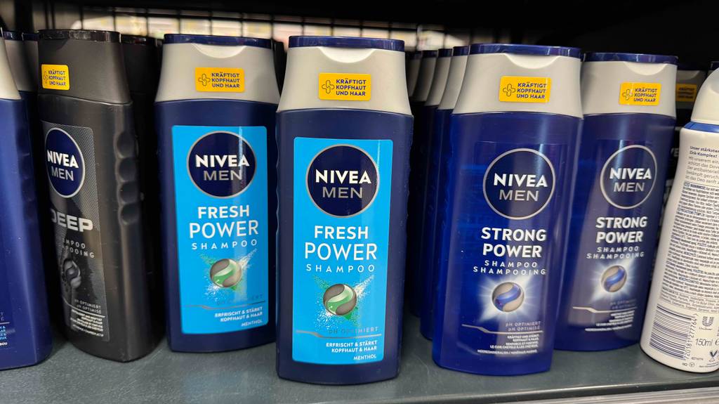 Männer-Shampoo im Test: Mehrere Behälter unterschiedlicher Sorten stehen neben- und hintereinander in einem Regal.