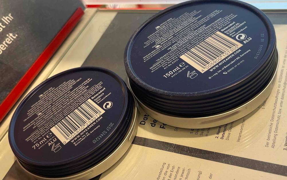 Zwei Dosen der Nivea-Men-Gesichtscreme im Test mit der Rückseite nach oben liegend.
