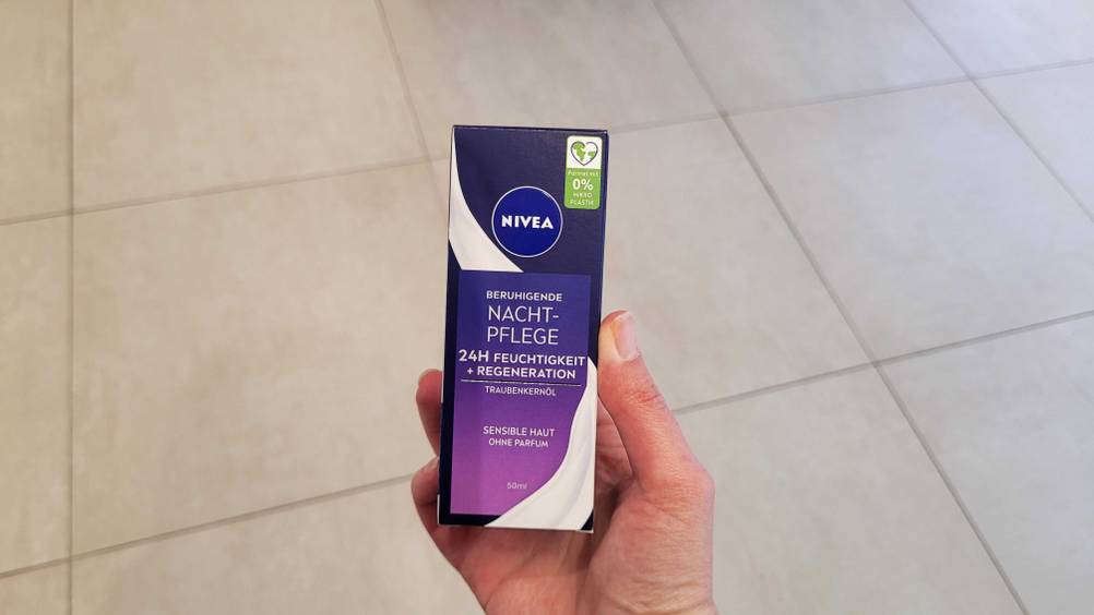 Eine Hand hält eine originalverpackte Nivea-Nachtcreme im Test hoch.