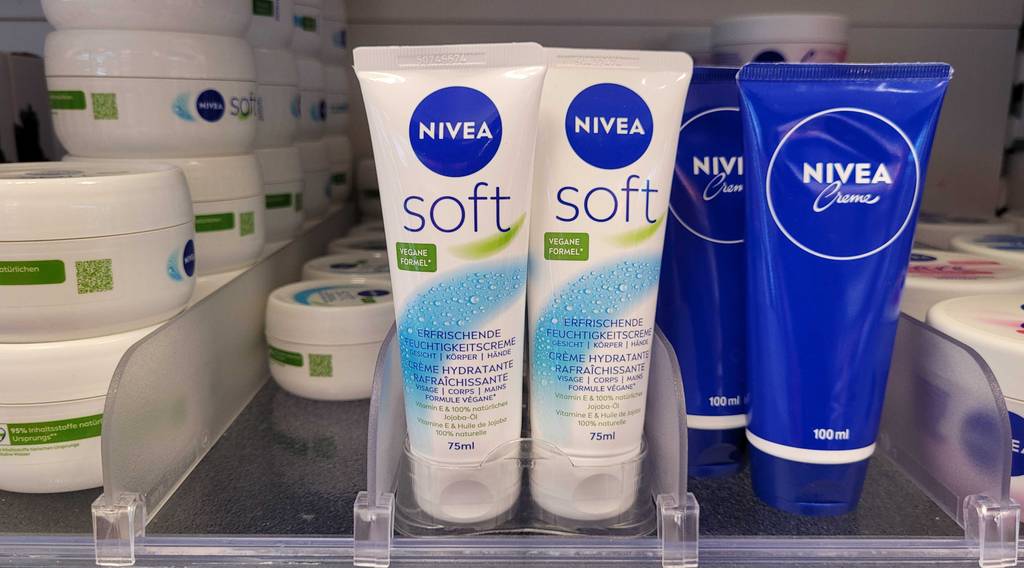 Mehrere Tuben Nivea-Gesichtscreme stehen zum testen in einem Regal zwischen anderen Pflegeprodukten.