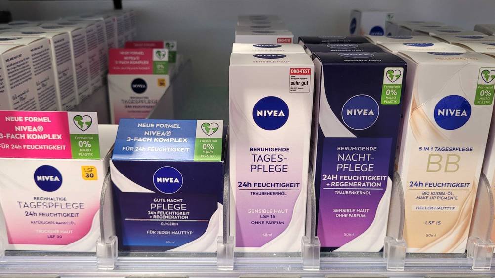 Mehrere Packungen der Nivea-Tagescreme im Test in einem Verkaufsregal neben anderen Produkten.