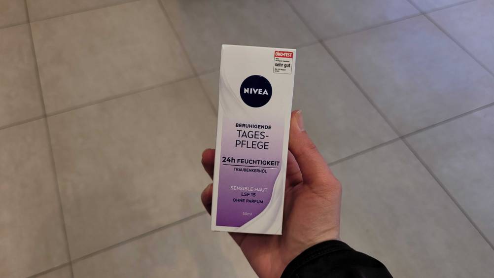 Eine Hand hält die getestete Nivea-Tagescreme hoch.