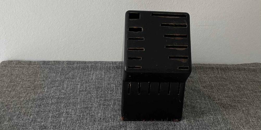 Ansicht von oben vorn auf einen getesteten Messerblock ohne Messer aus Holz inklusive schwarzer Lackschicht mit Platz für 12 Messer.