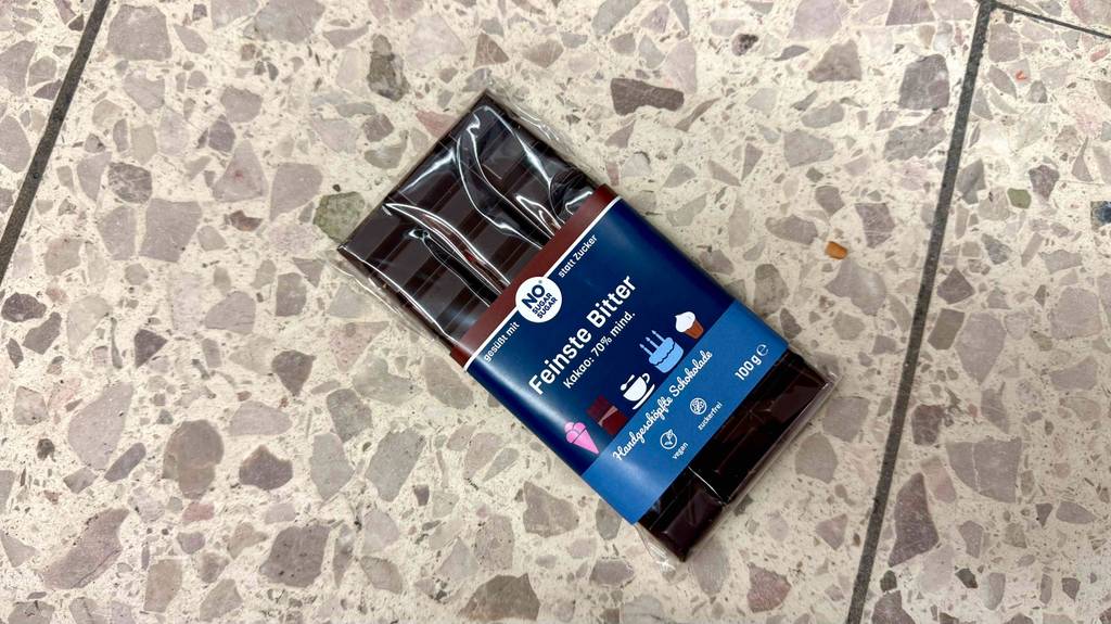 Eine Tafel zuckerfreie-Schokolade liegt zum testen auf einer Fliese.
