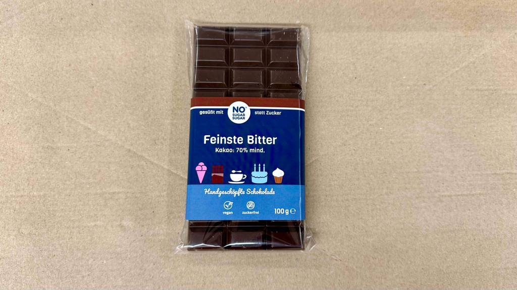 Auf der Verpackung einer Tafel getestete zuckerfreie Schokolade stehen Informationen zum Inhalt.