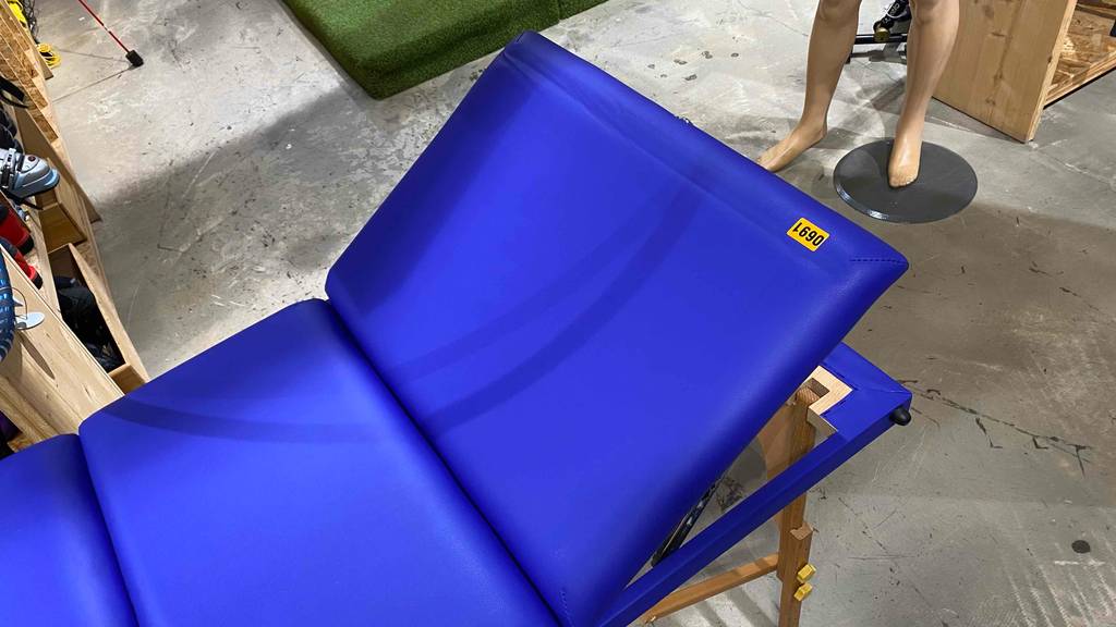Detailansicht des höhenverstellbaren Kopfbereichs einer blauen Massageliege im Test.