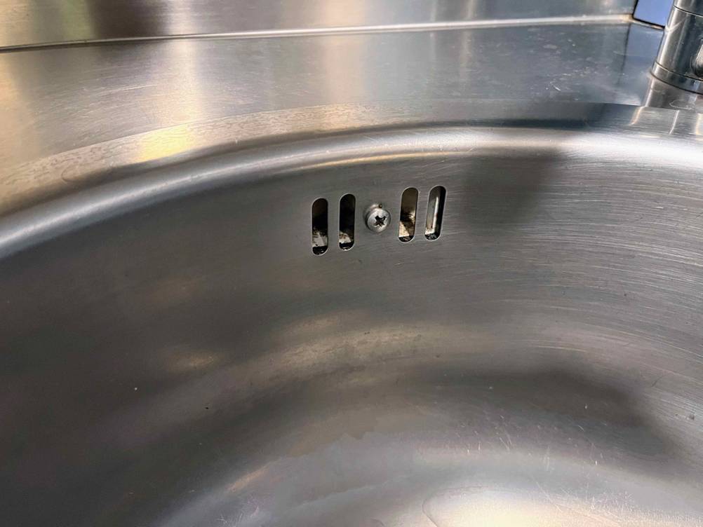 Detailaufnahme einer getesteten Küchenspüle aus Edelstahl, mit Fokus auf den seitlichen Ablauf.