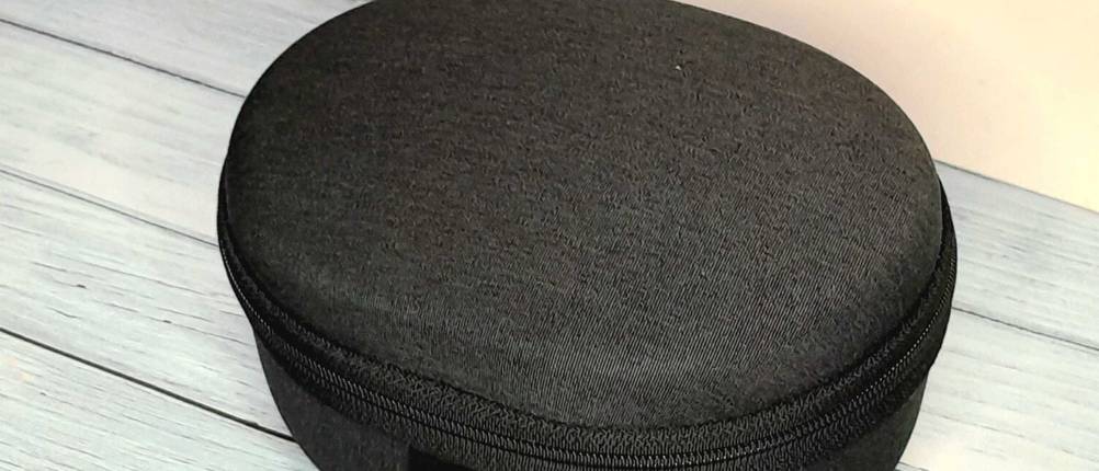 Noise-Canelling-Kopfhörer-Test: schwarzes Schutzcase für Noise-Cancelling-Kopfhörer auf einer hellblauem Holzuntergrund
