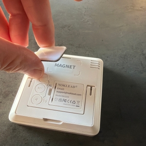 Eine Hand befestigt einen Magneten am Noklead-Hygrometer