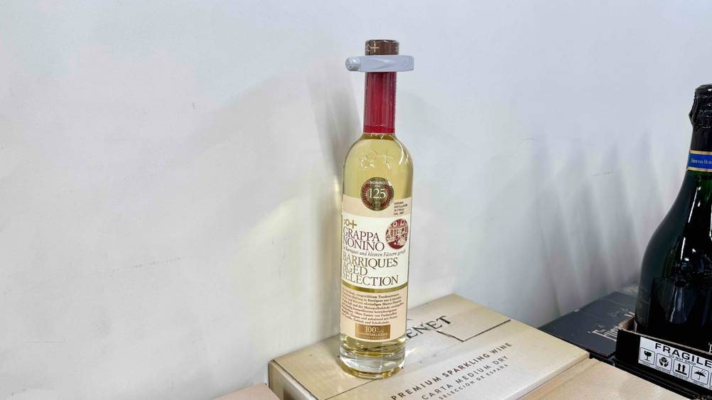 Vor einer hellen Wand auf einem Karton steht eine Flasche des getesteten Nonino-Grappas.