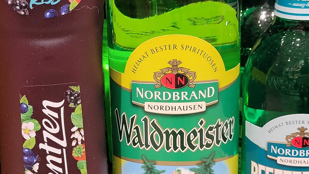 Auf der Frontseite einer Flasche getesteter Waldmeisterlikör steht der Hersteller.