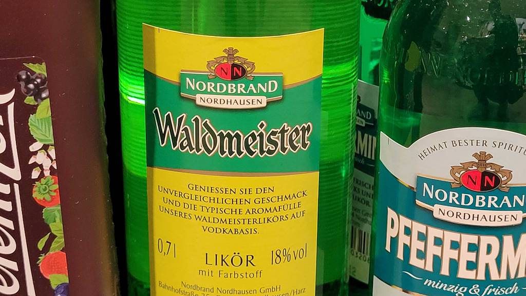 Auf der Rückseite einer Flasche Waldmeisterlikör im Test stehen Informationen zum Inhalt und Alkoholgehalt.