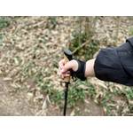 Eine Hand hält den Griff eines Alpidex Nordic-Walking-Stocks. Der Korkgriff liegt sicher in der Hand, eine Schlaufe ist um das Handgelenk gelegt.