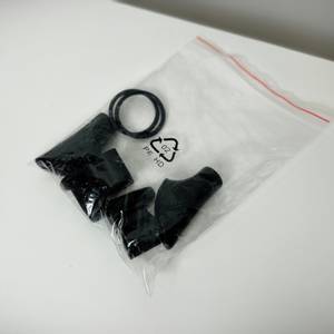 Mehrere Gummiaufsätze für Alpidex-Nordic-Walking-Stöcke liegen in einem Plastikbeutel auf weißem Untergrund. Die Aufsätze sind verpackt.