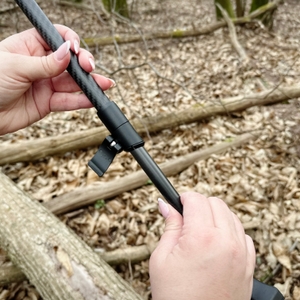Zwei Hände stellen die Länge eines Gipfelsport-Nordic-Walking-Stocks ein. Der Drehverschluss wird festgezogen.