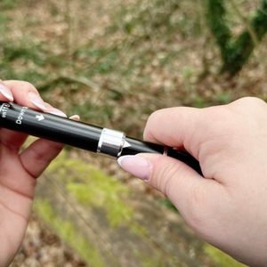 Zwei Hände halten ein schwarzes Segment eines Glymnis-Walking-Stocks. Es wird gerade auseinandergezogen.