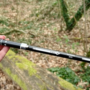 Zwei Hände halten ein Segment eines Glymnis-Walking-Stocks. Der Stock wird zum Zusammensetzen vorbereitet.