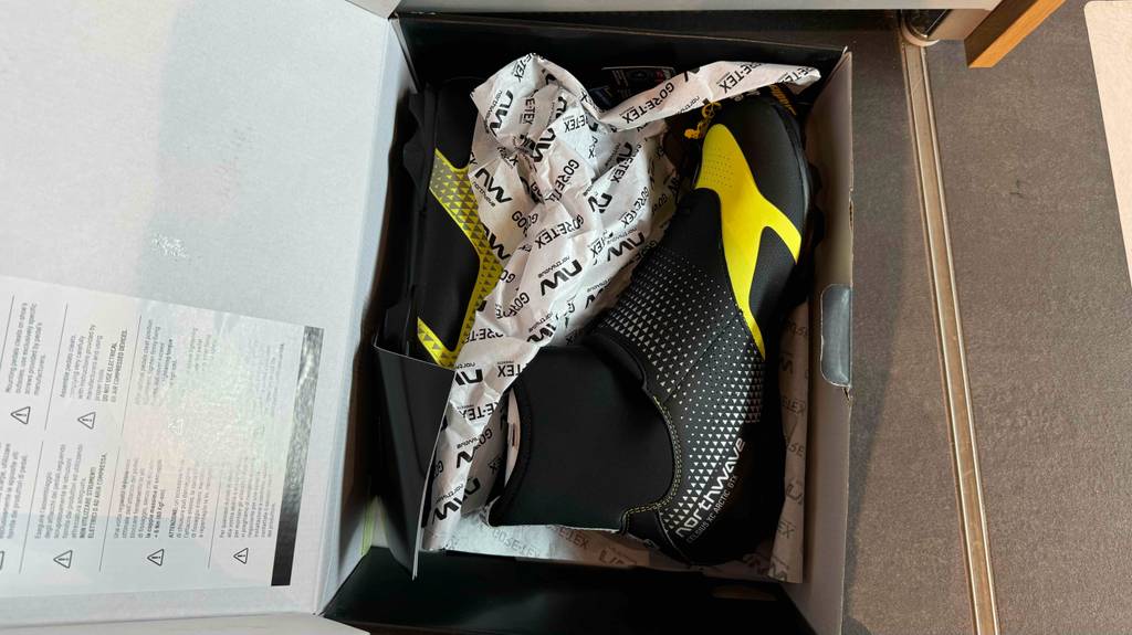 Ein Paar Fahrradschuhe für den Winter liegen getestet im Schuhkarton.