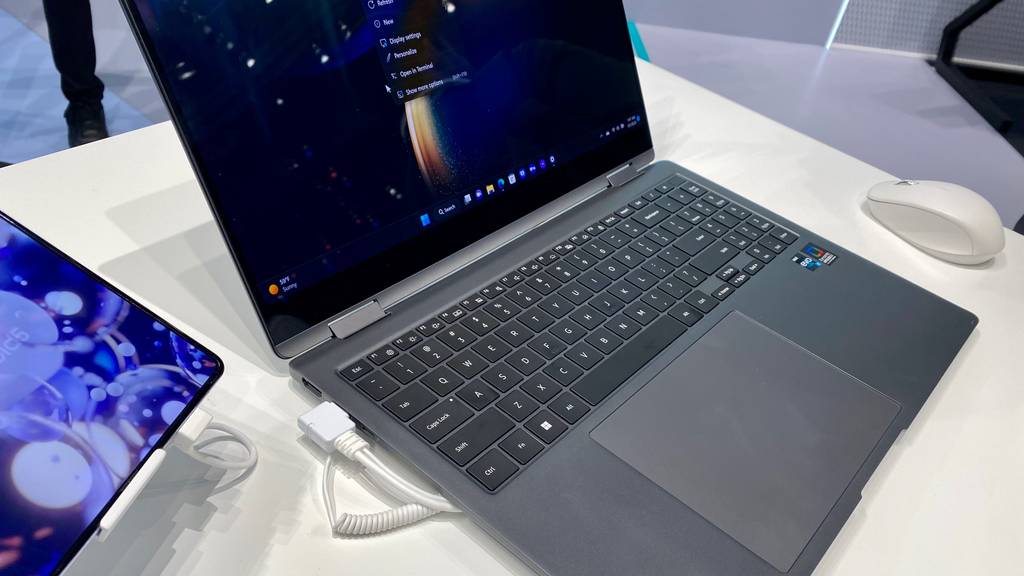 Angeschlossenes Notebook-mit-Touchscreen im Test befindet sich zwischen der Computermaus und einem Tablet.