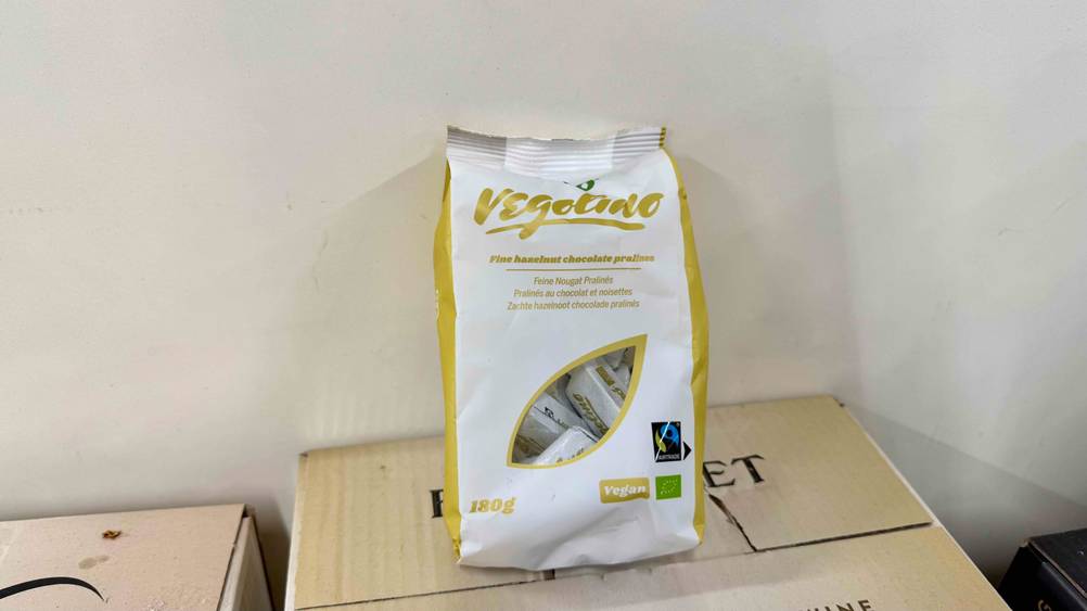 Eine Packung der getesteten Nougat-Pralinen auf einem Karton vor einer hellen Wand.