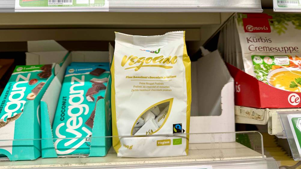 Mehrere Packungen der Nougat-Pralinen im Test in einem Verkaufsregal neben anderen Produkten.