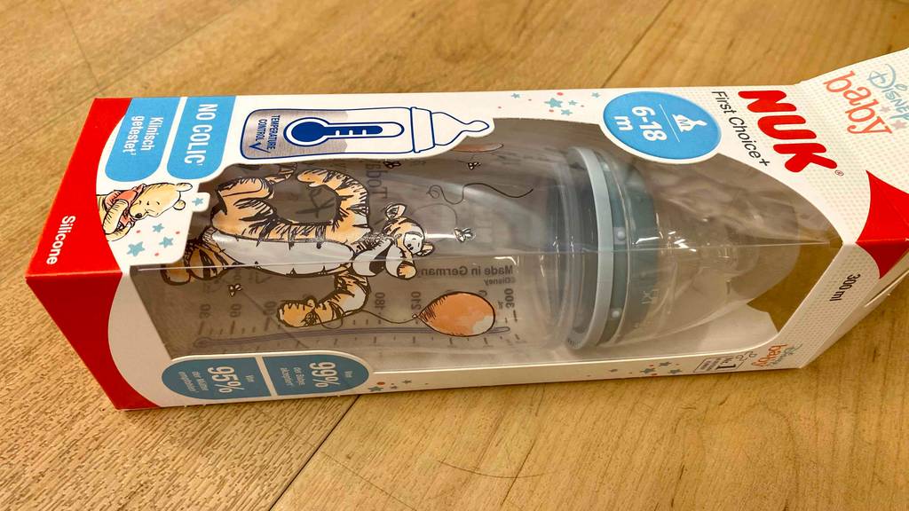 NUK Babyflasche in Verpackung liegt auf einer Holzunterlage