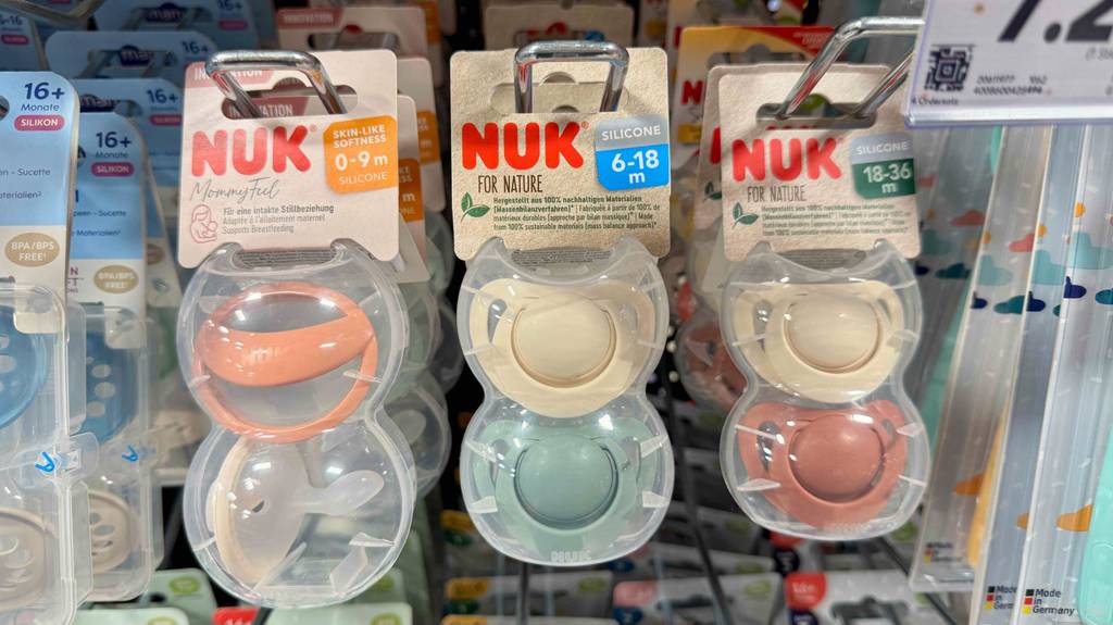 Mehrere NUK-Schnuller im Test hängen an einem Verkaufsregal.