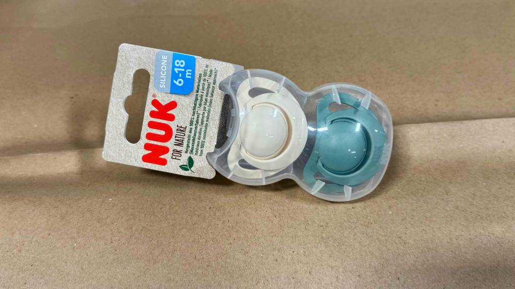 NUK-Schnuller im Test: Eine Verpackung mit zwei Schnullern liegt auf einer braunen Oberfläche.