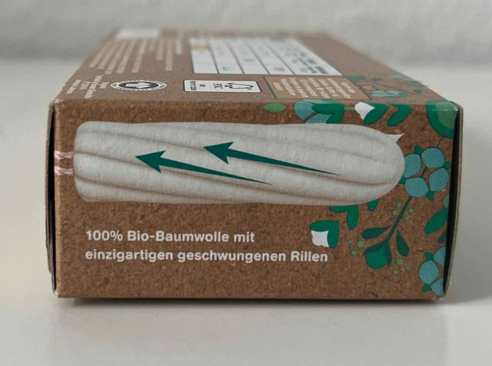 Bio-Tampons-Test: Ansicht der schmalen Seite einer braunen Verpackung o.b. Organic inklusive Abbildung eines weißen Tampons mit geschwungenen Rillen.