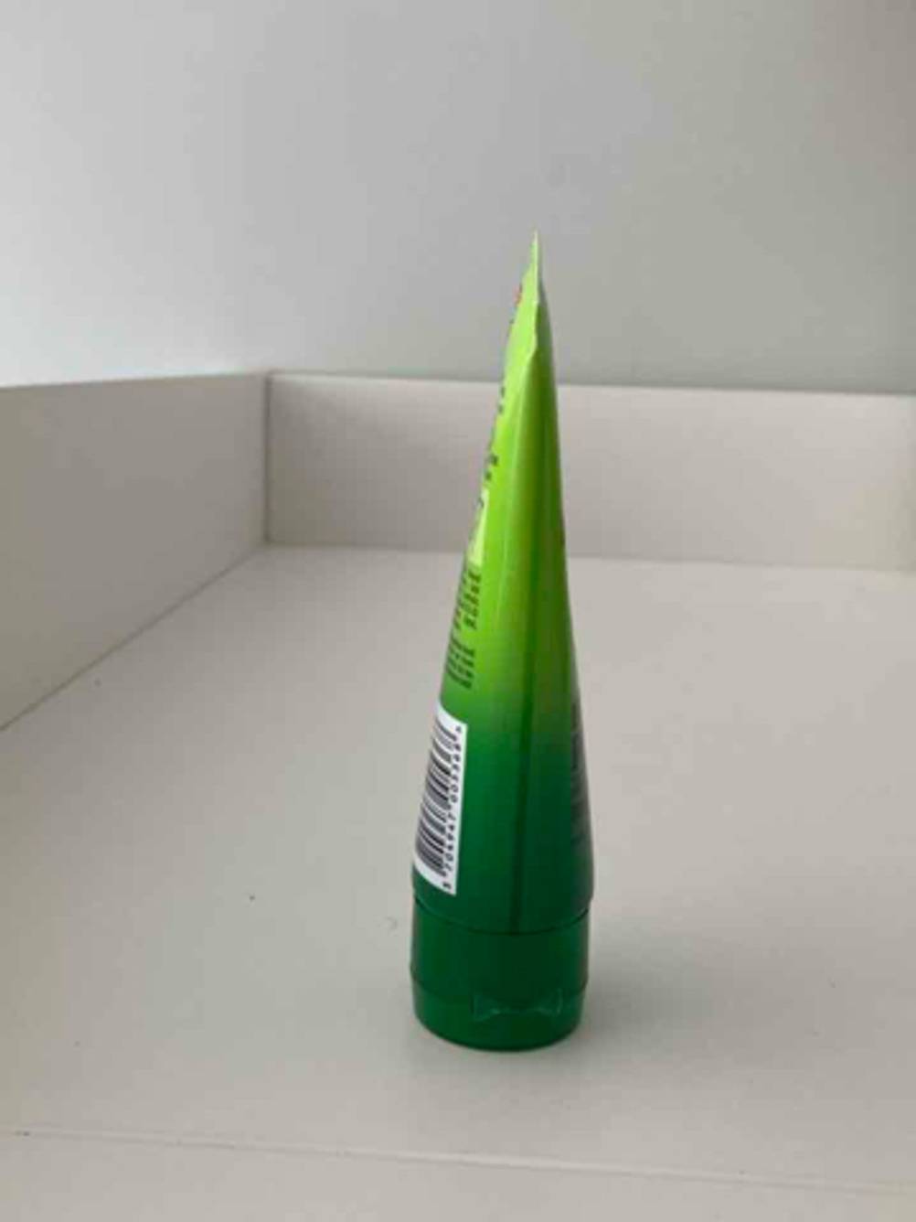 Die Hautschutzcreme im Test in der grünen Tube steht auf dem Deckel in einem weißen Regal.