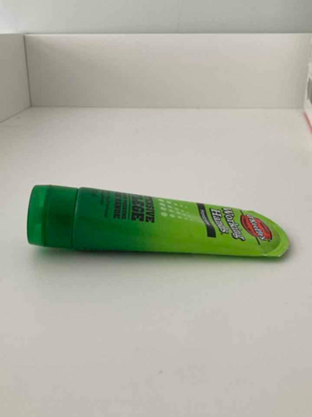 Die Hautschutzcreme im Test befindet sich in einer grünen Tube, die auf einer weißen Oberfläche liegt.
