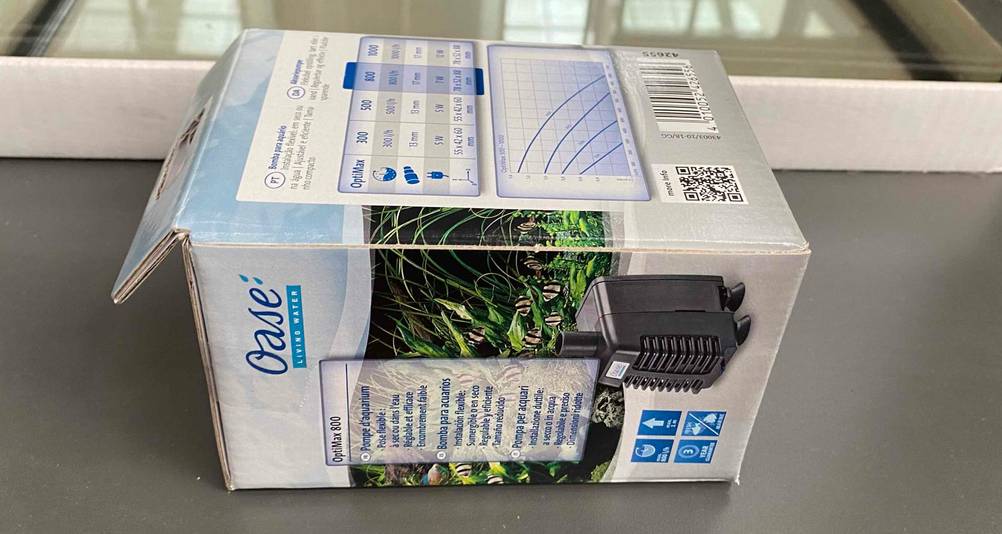 Helle Originalverpackung einer Aquarium-Pumpe im Test liegt mit Fokus auf die aufgedruckten Produktinformationen auf einem grauen Boden
