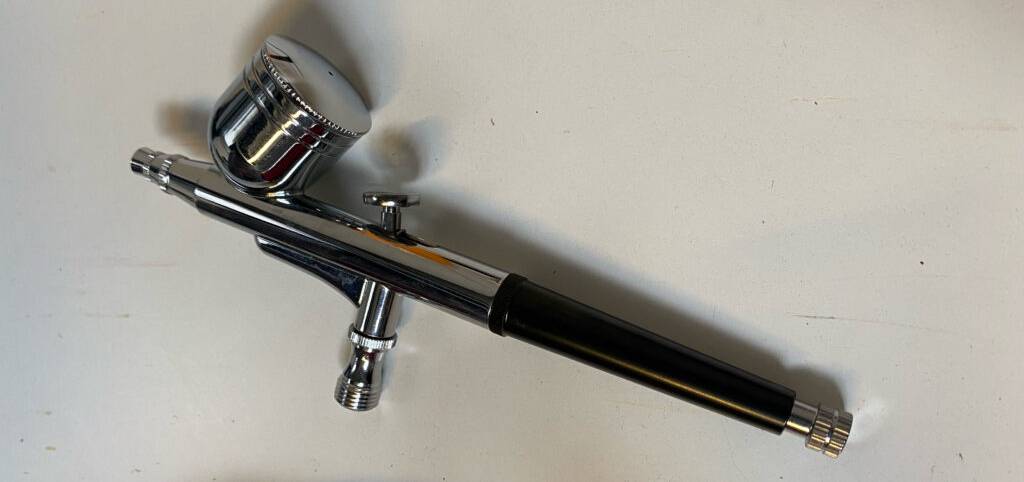 Airbrush-Set-Test: Ein Airbrush ohne Schlauch liegt auf einer weißen Oberfläche.