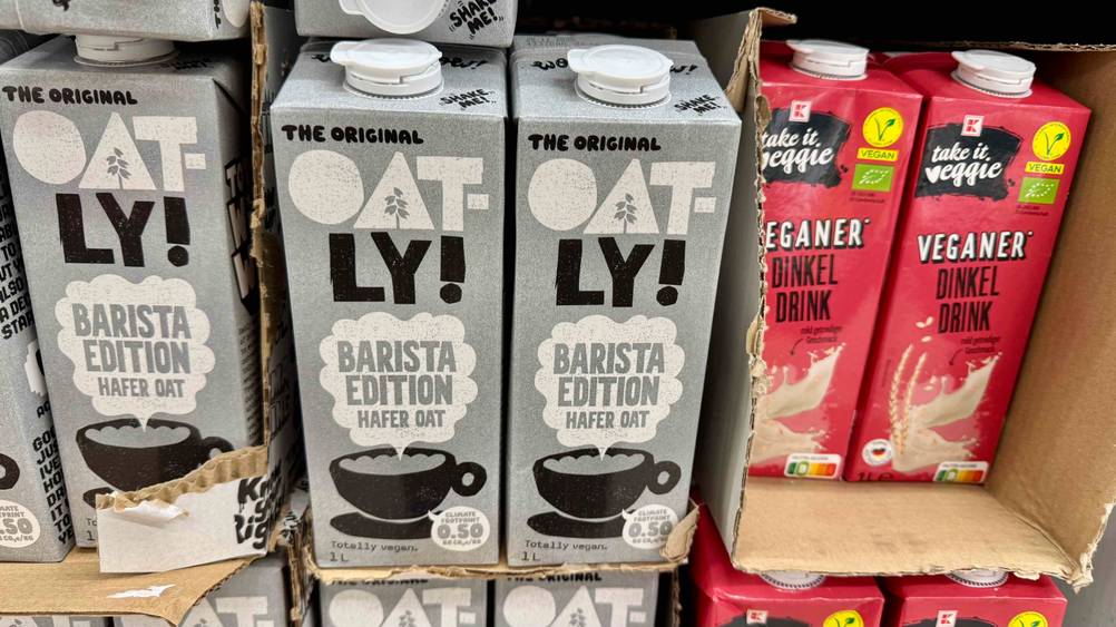 Mehrere Packungen des Oatly-Haferdrink im Test in einem Verkaufsregal neben anderen Produkten.