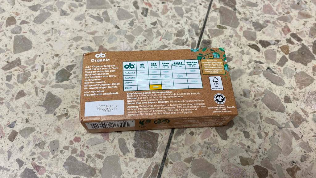 Bio-Tampon getestet: Rückseite der Verpackung liegt auf Fliesenboden.