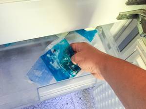Oberschenkelbandage-Test: Eine Person legt ein Kühlpad in den Gefrierschrank.