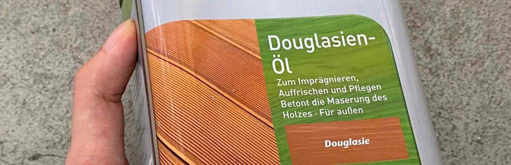 Im Test: Öl für Douglasienholz, das als Metallgebinde in einer Hand gehalten wird.