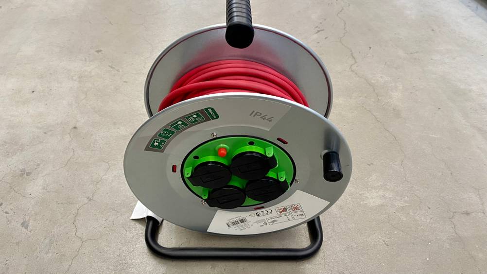 25-m-Kabeltrommeln im Test: ein Modell inklusive rotem Kabel und vier Steckern von oben betrachtet.