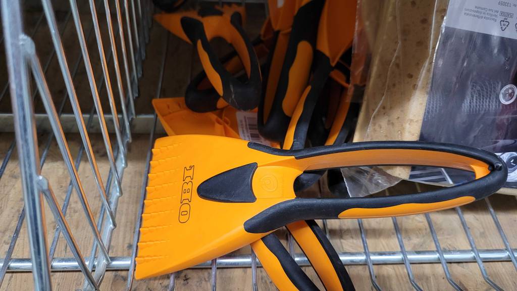 Eiskratzer-Test: ein orange-schwarzes Modell von OBI liegt in einem Verkaufskorb.
