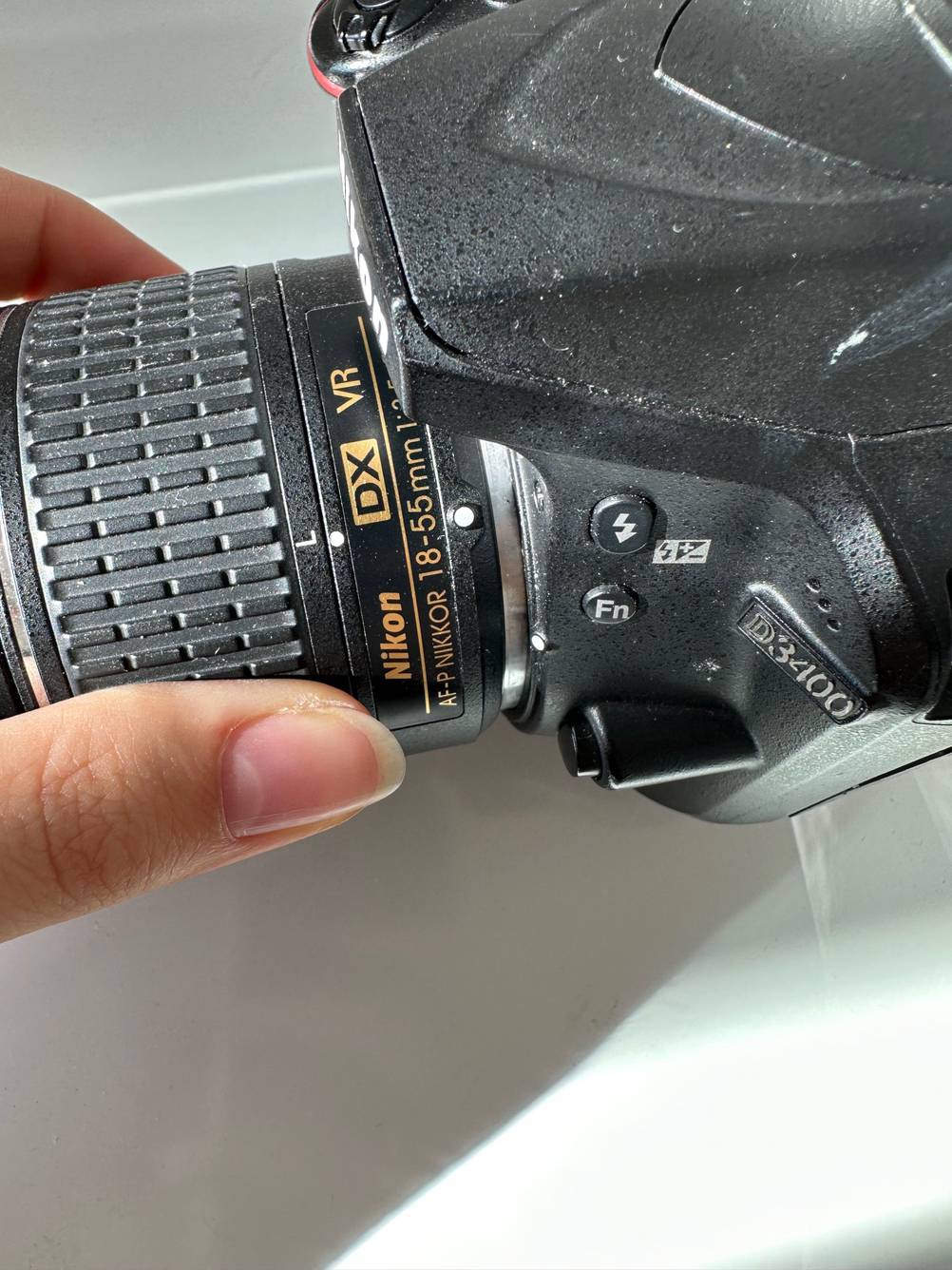 Eine Hand verstellt die Blende von einem getesteten Objektiv für eine Nikon-Kamera.