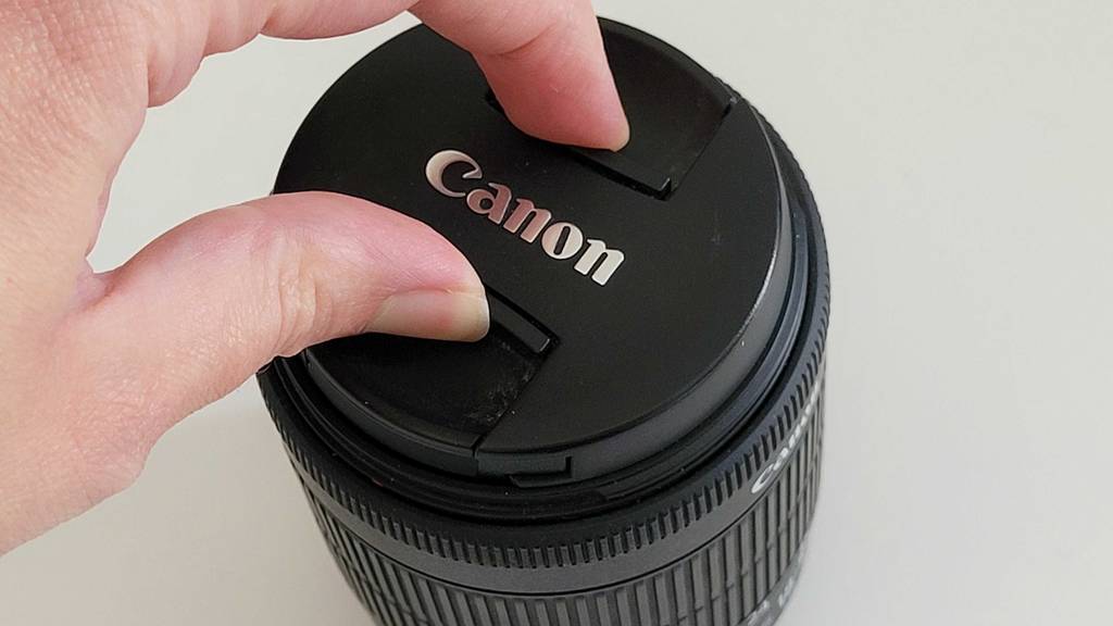Schutzkappe von einem schwarzen Objekt der Marke Canon. 