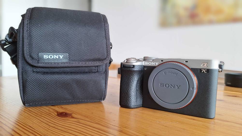 Eine getestete Objektivtasche neben einem Kamerabody auf einem Holztisch.
