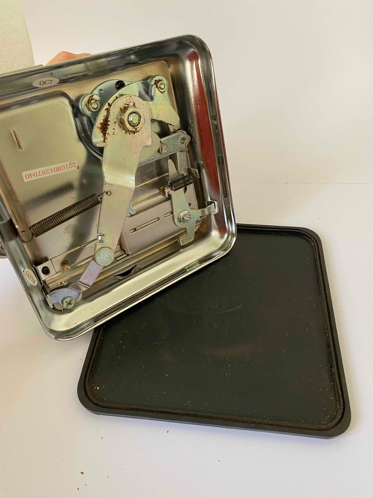 Die getestete Zigarettenstopfmaschine steht auf der Seite auf ihrem schwarzen, abnehmbaren Kunststoffboden.