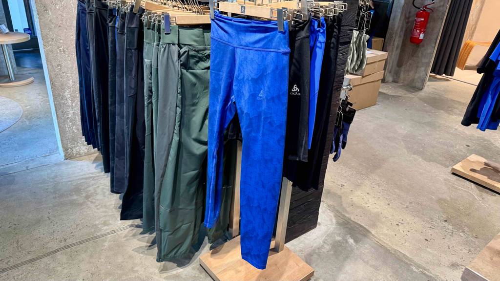 Die leuchtend blaue Damen-Langlaufhose im Test hängt mit weiteren verschiedenfarbigen Langlaufhosen an einem Ständer im Geschäft.