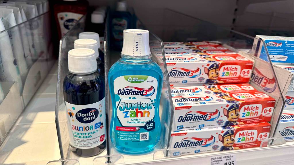 Getestete Kinder-Mundspülung in Kunststoffflaschen befindet sich in einem Verkaufsregal neben Zahnpflegeprodukten für Kinder.